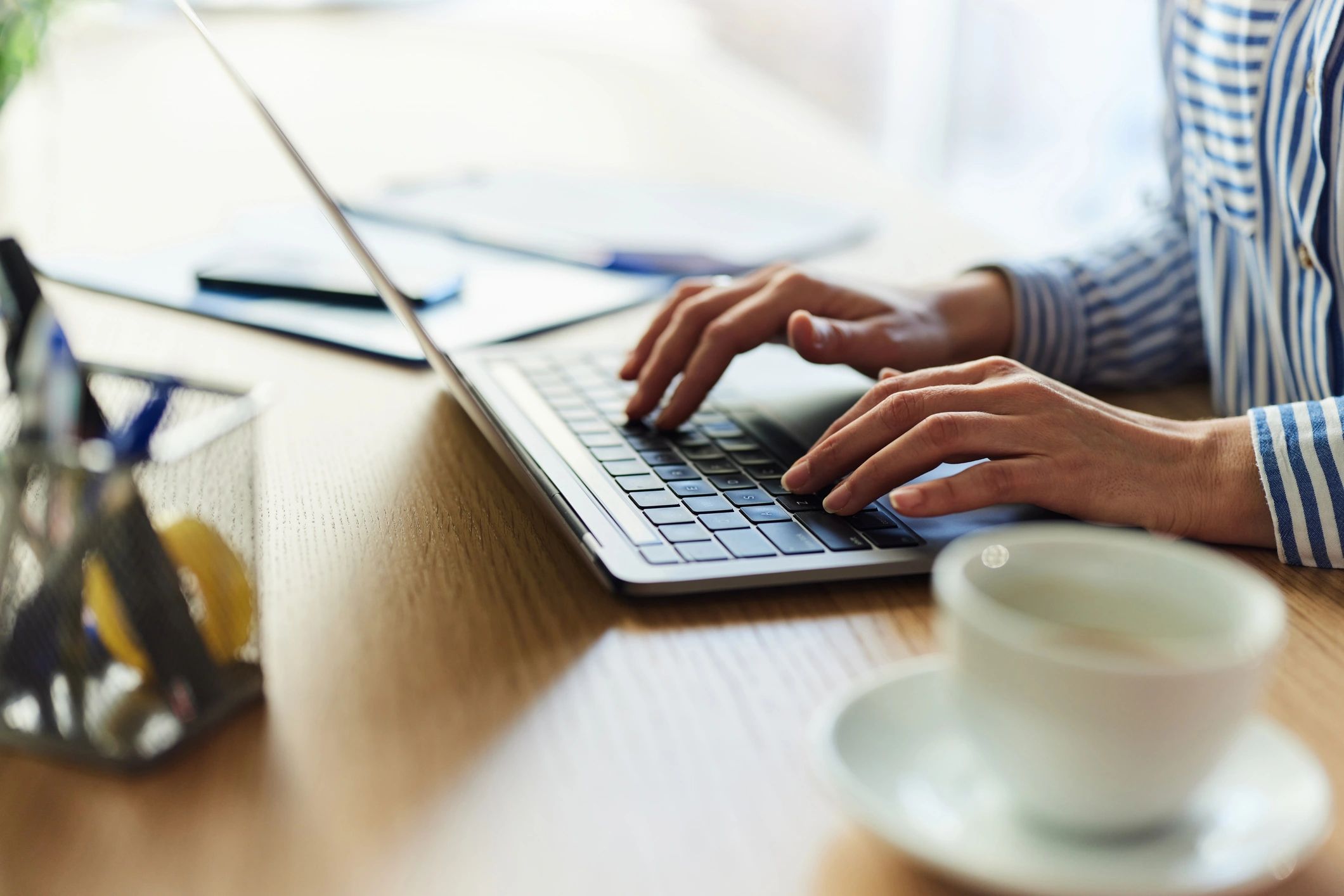 Hands typing at a desk