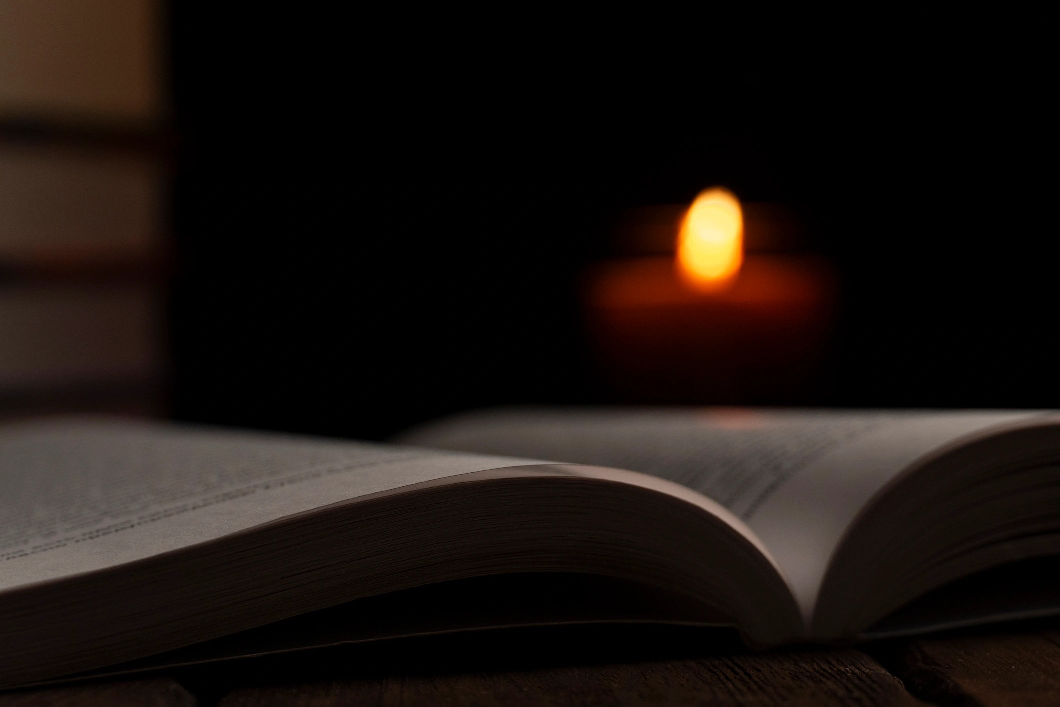 Open book by candlelight in a dark atmosphere