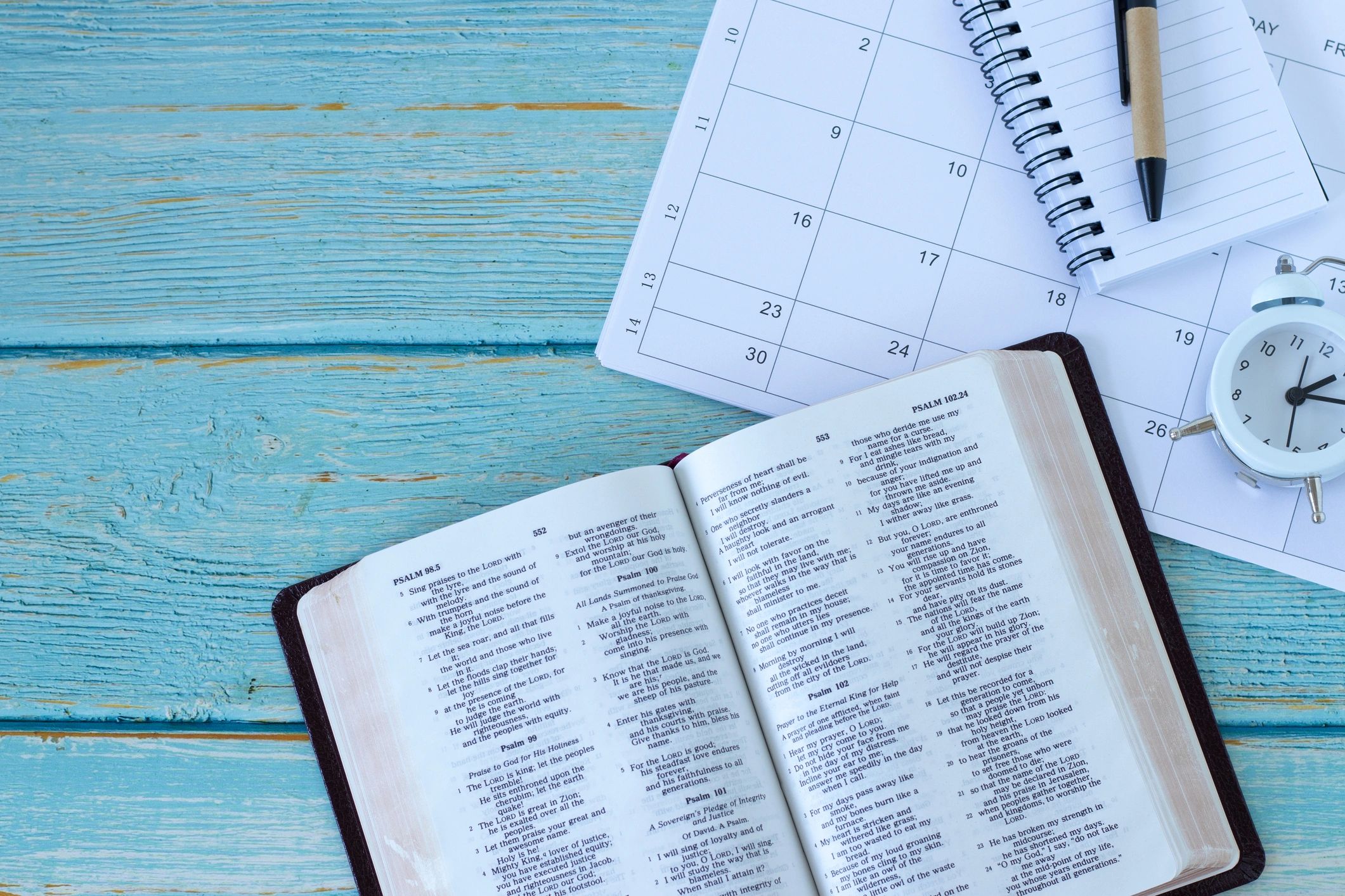 Open Bible with notebook and clock