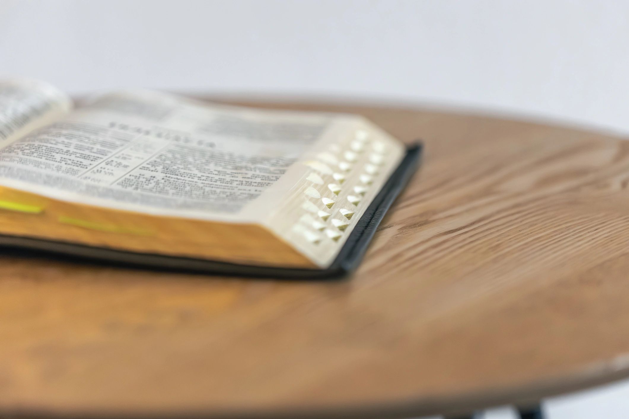 Open Bible on a wooden table in soft light